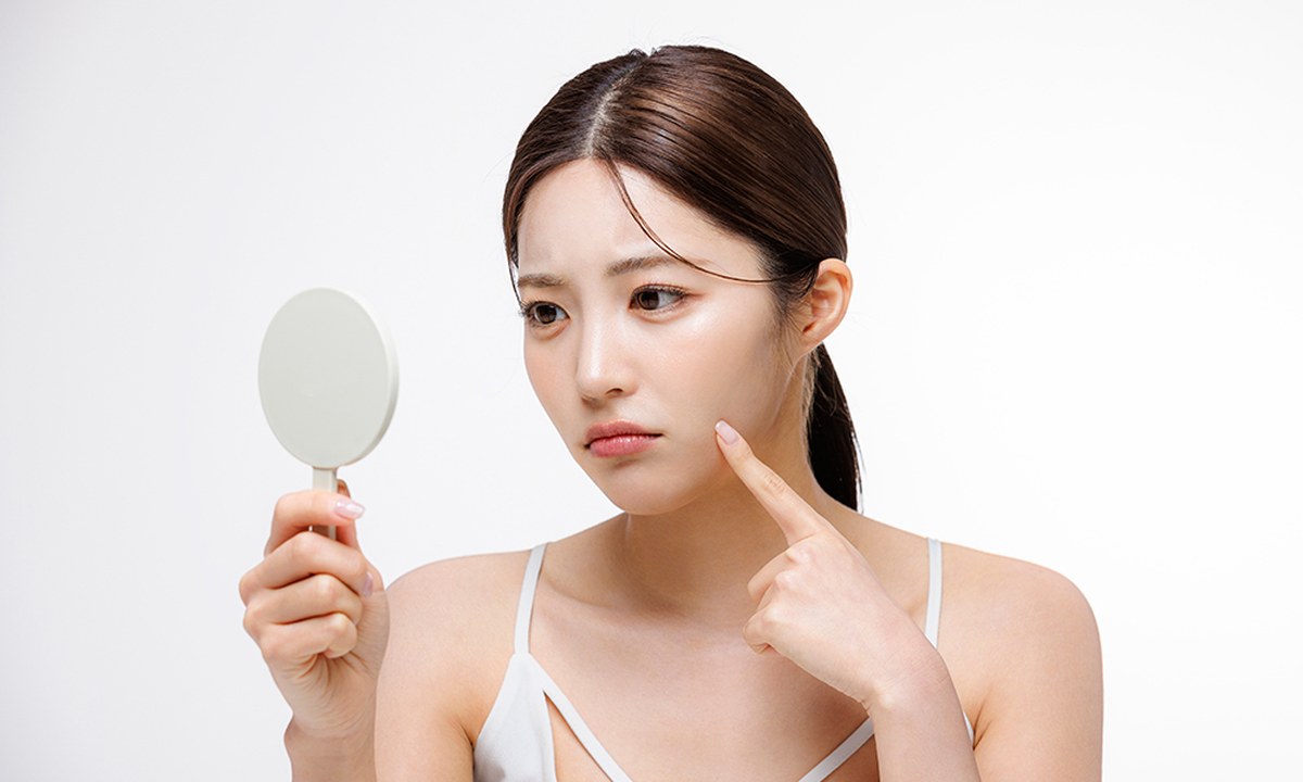 거울로 볼 피부 상태를 살펴보는 색소질환 클리닉 모델 이미지